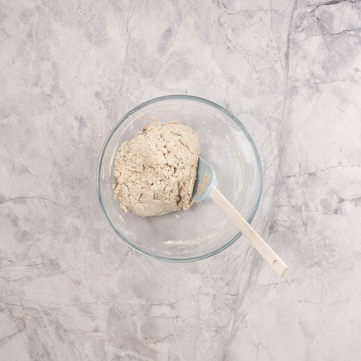 Dough of Monkey bread combined together in a large bowl with spatula.