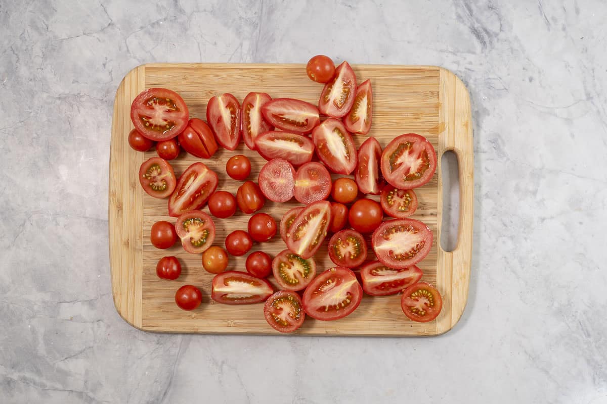 Chopped tomatoes on a wooden chopping board.