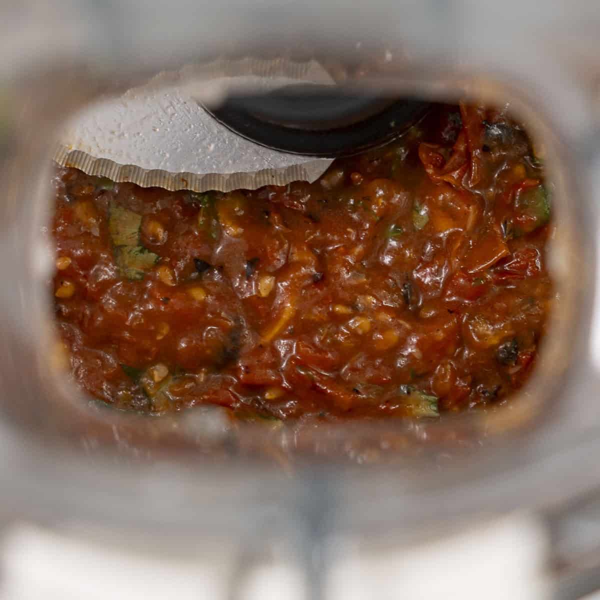 Roasted tomatoes blended together inside food processor.