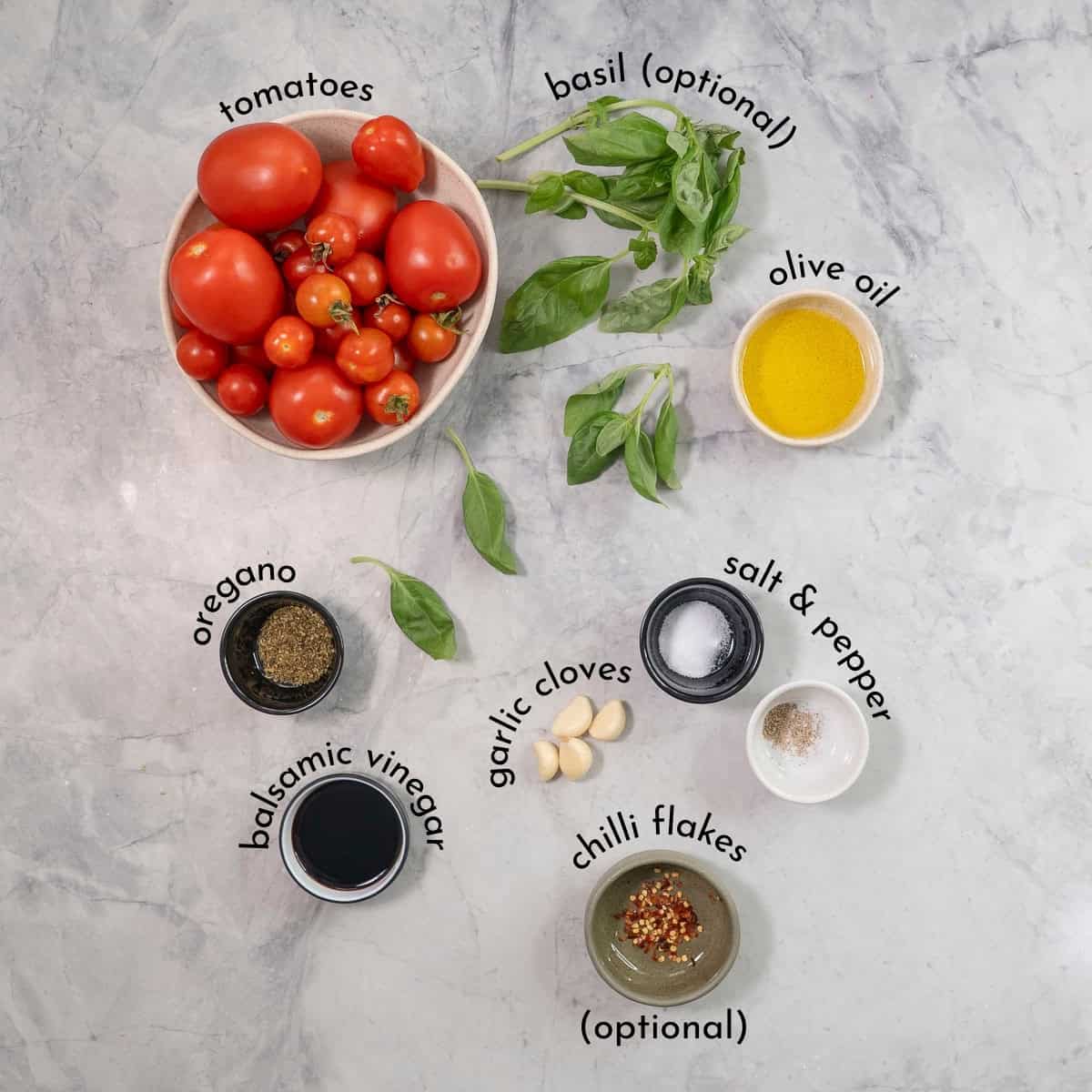Ingredients for roasted tomato sauce on bench top with text overlay.