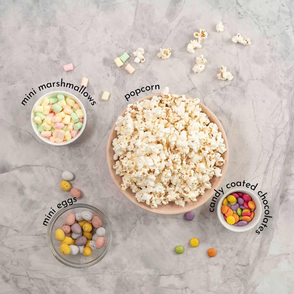 Ingredients for easter popcorn on bench top with text overlay.