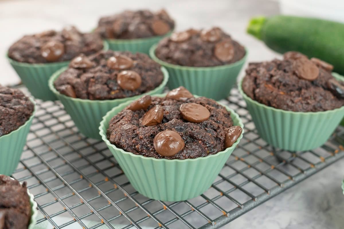 Chocolate chip muffins in green silicone mold on a cooling rack.