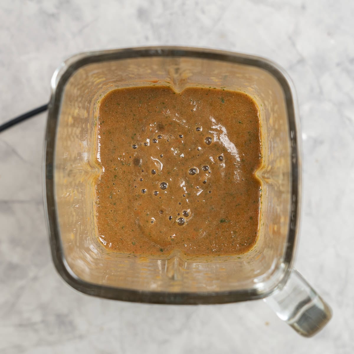 Spinach and passata blended together in blender on benchtop.