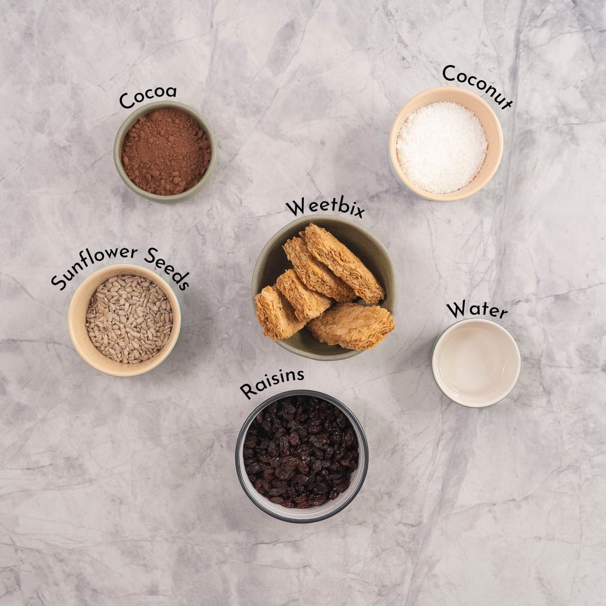 Ingredients for weetbix balls on bench top with text overlay,