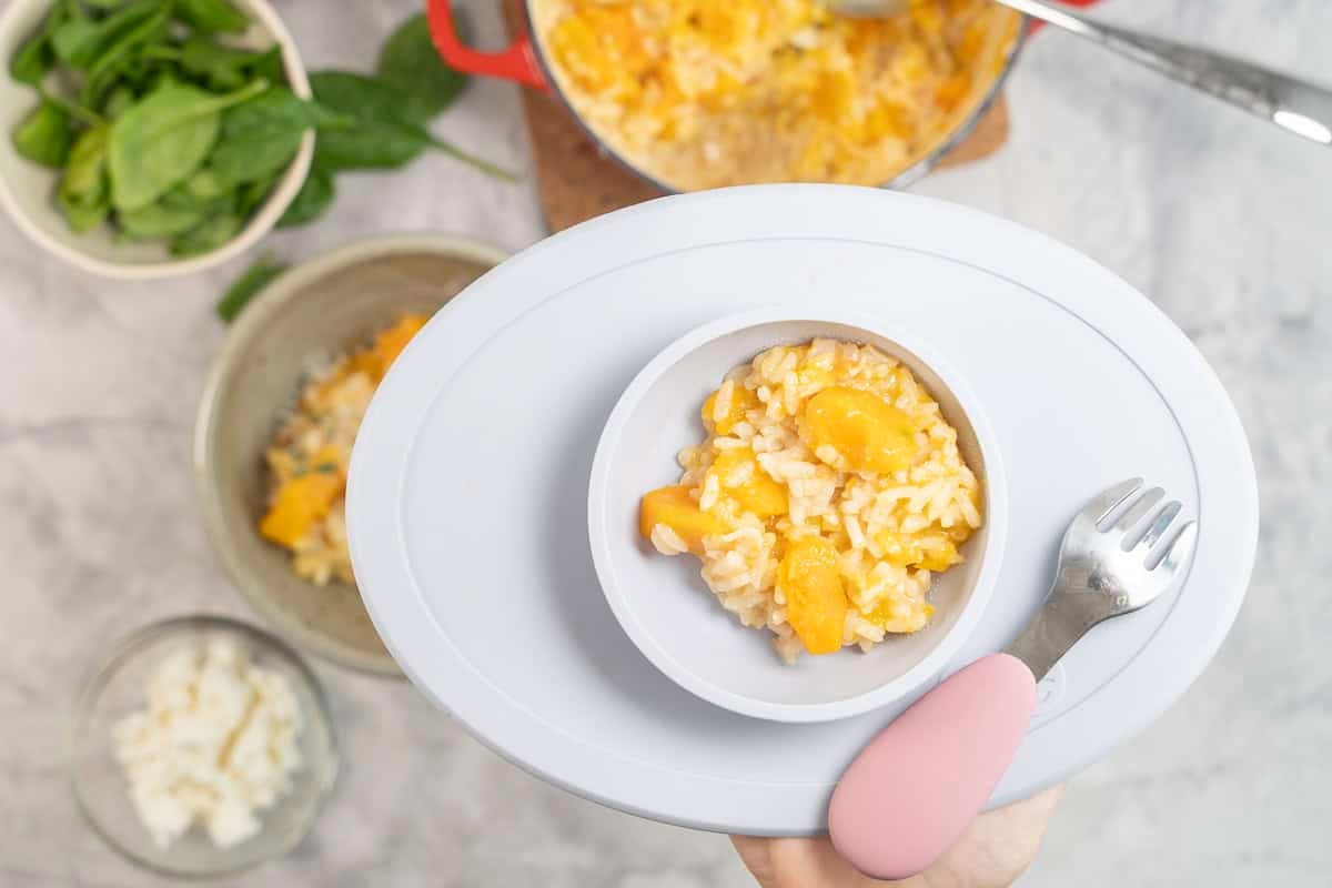 Baby silicone bowl with baked pumpkin risotto inside.