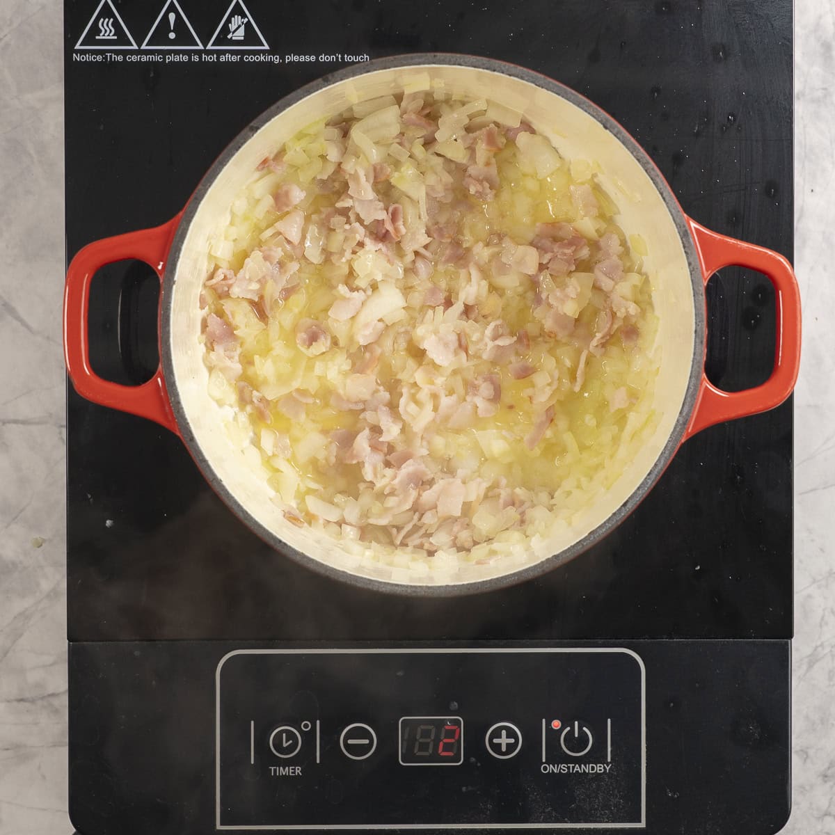 Onion and bacon sautéing on stove top.