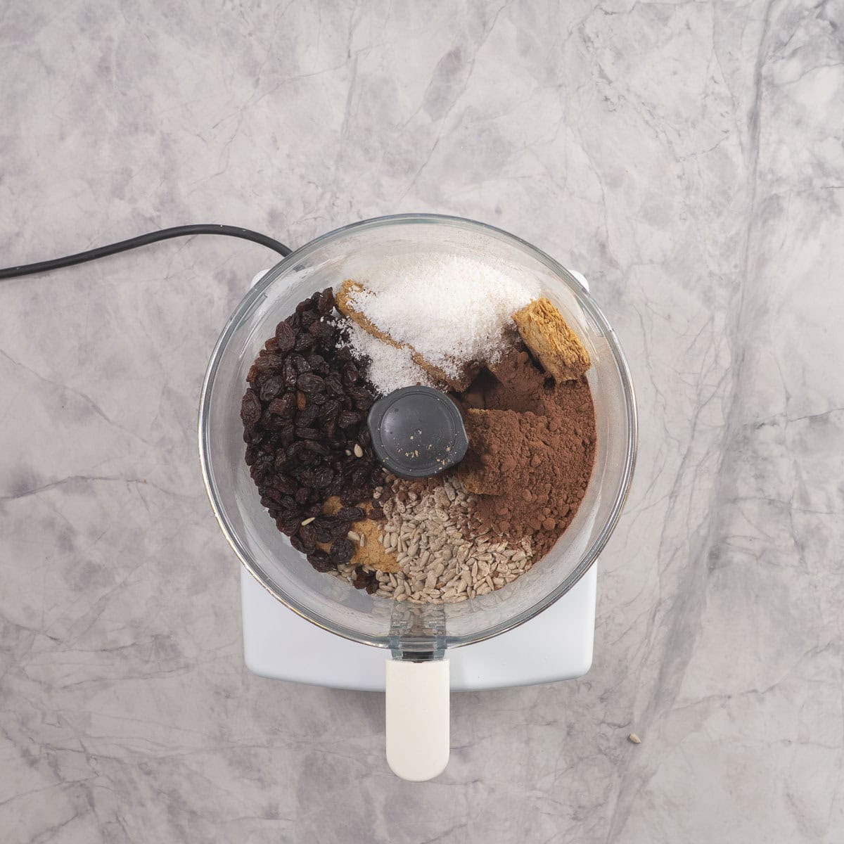 Ingredients for weetbix balls in food processor on benchtop.