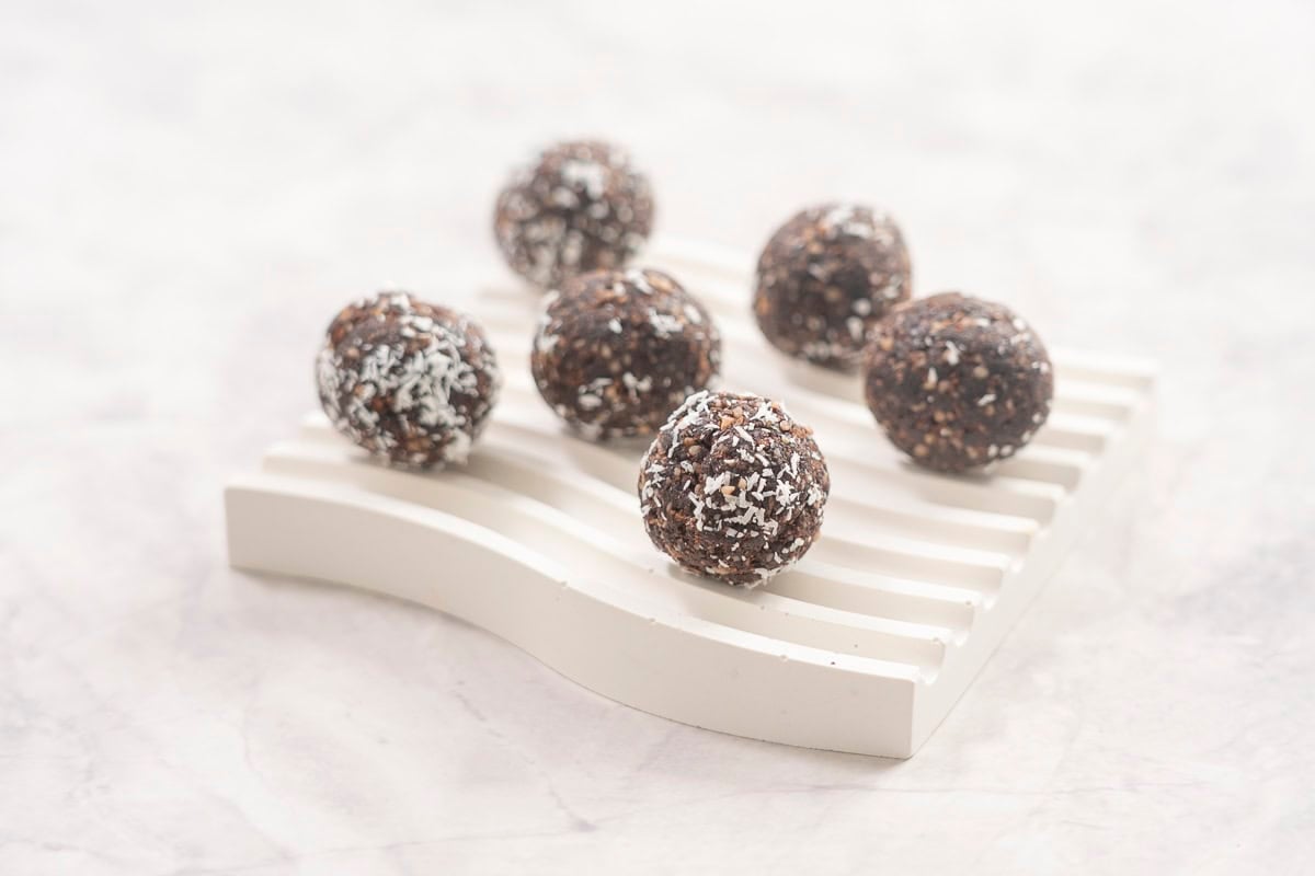 Weetbix bliss balls on small ramekin on benchtop.