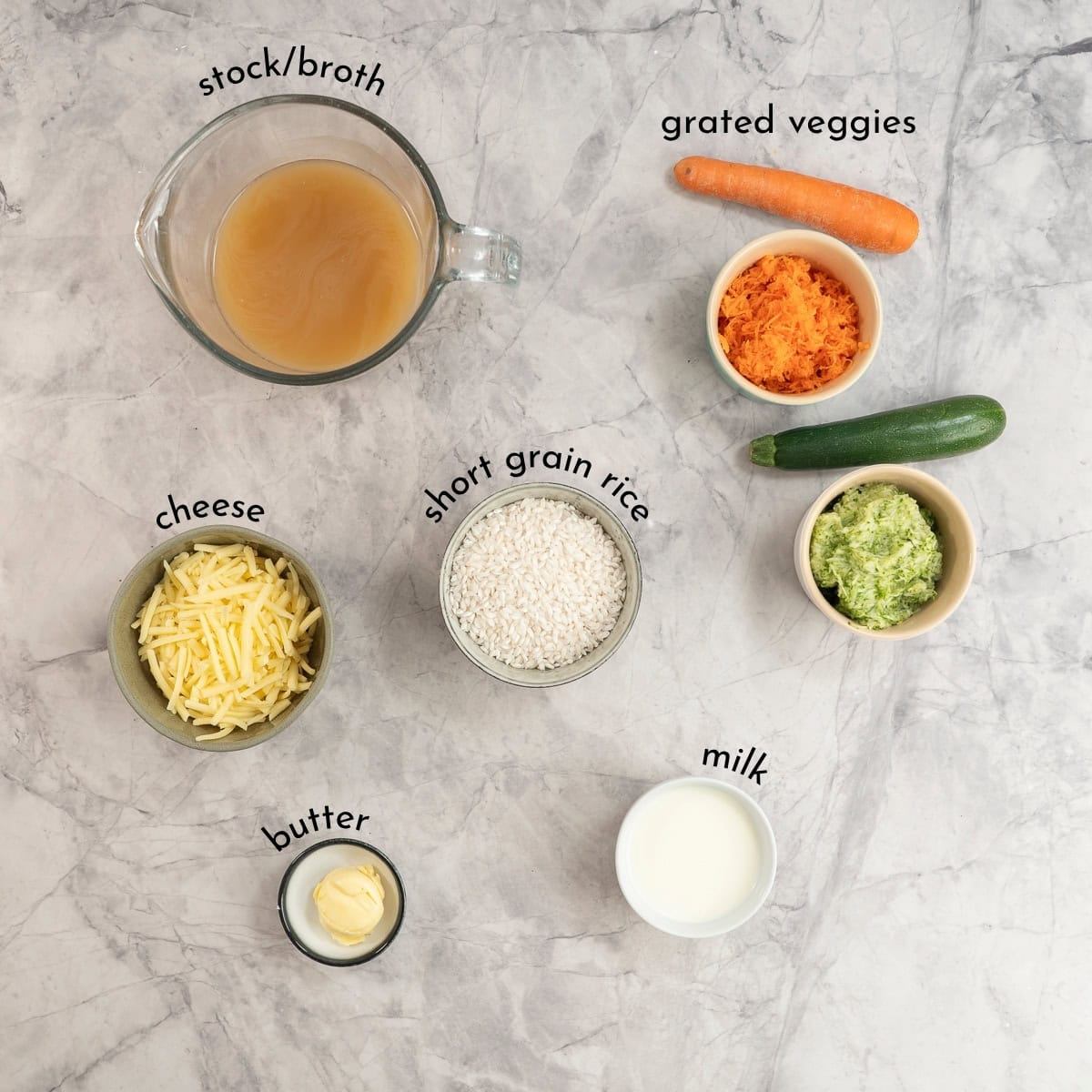 Ingredients for cheesy rice on marble bench top with text overlay.