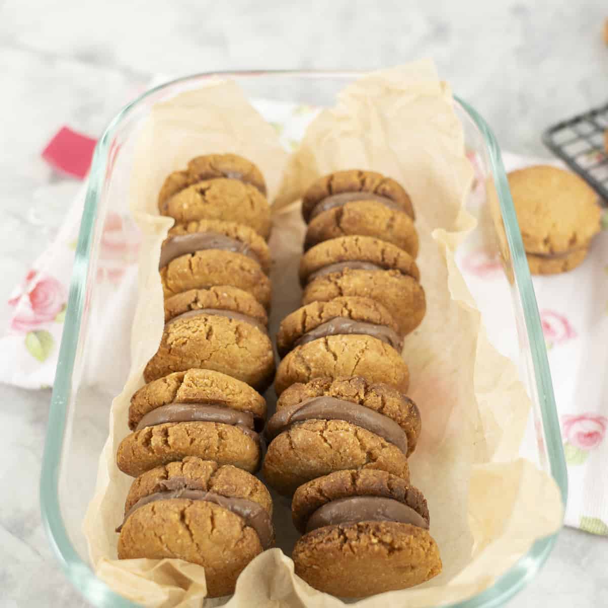 Glass container with two rows of peanut butter sandwich cookies inside.