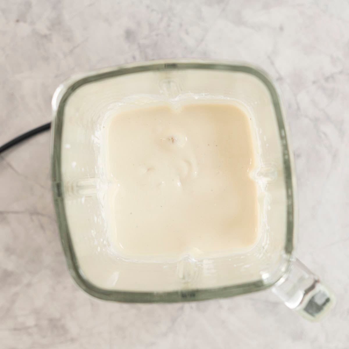 Smooth blended mixture for healthy banana pudding in blender.