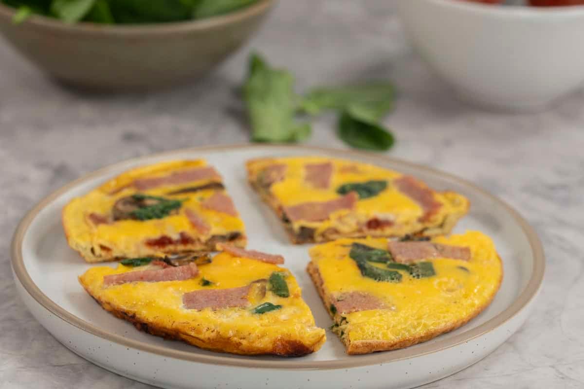 Pizza eggs sliced into four pieces on a plate.