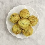Six muffins packed with vegetables on a white plate.