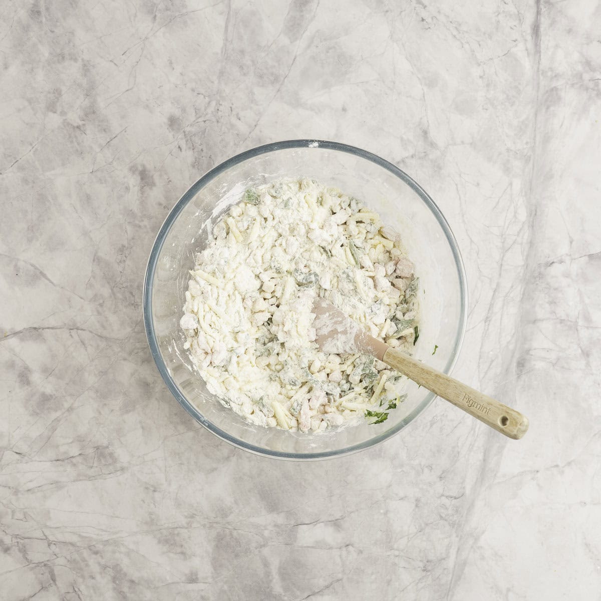 Wooden spoon inside ingredients for muffins mixing flour and vegetables together.