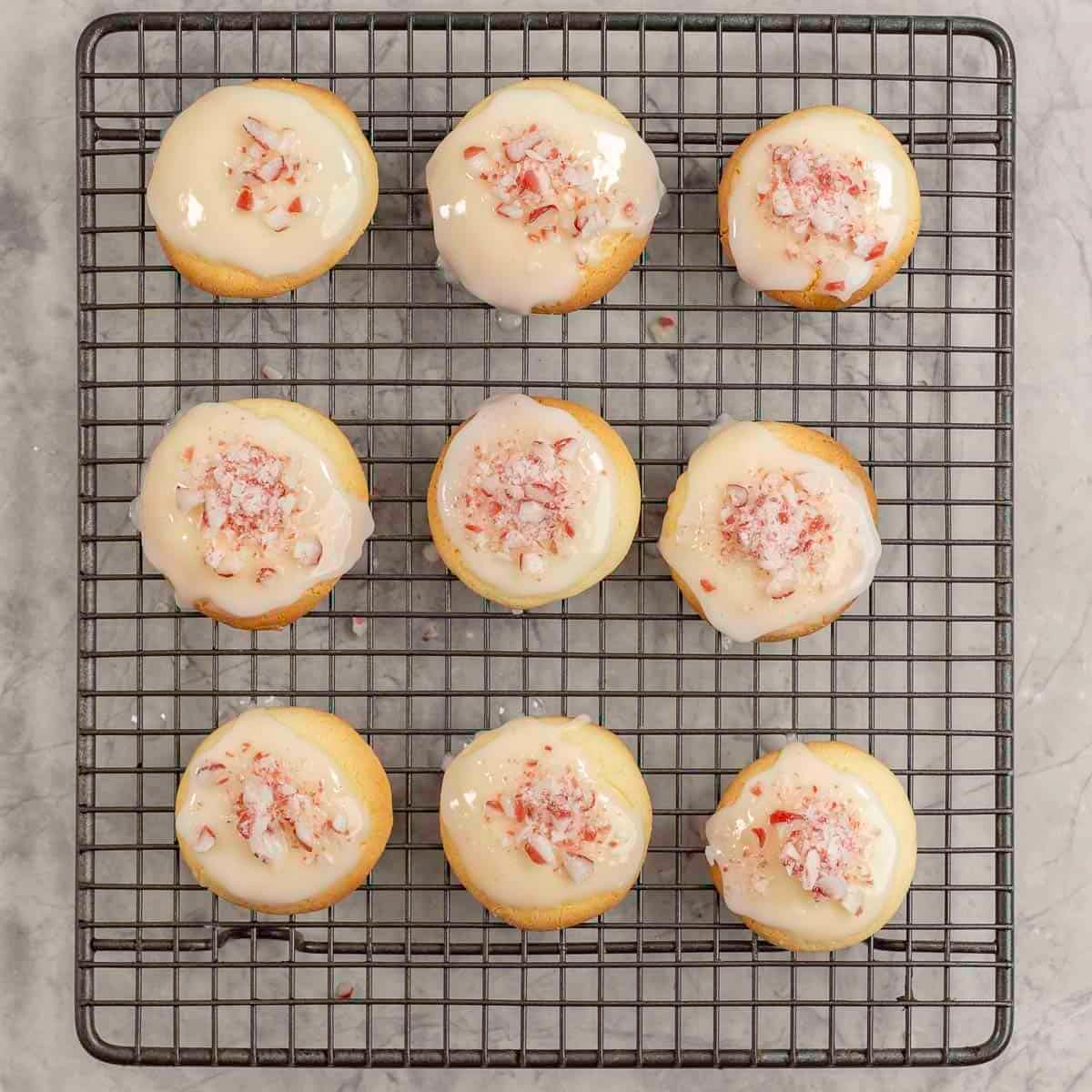 Cooling tray with nine cookies, decorated with icing and crushed candy cane.