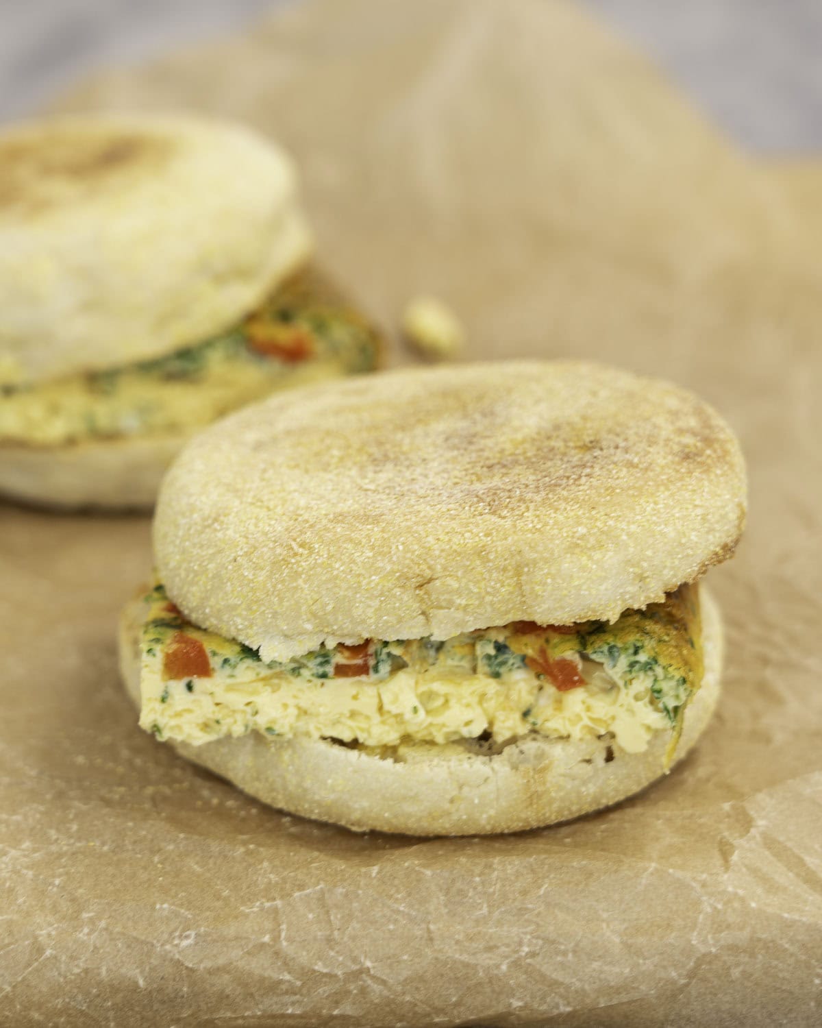 Two toasted breakfast muffins with a square slice of sheet pan eggs inside.