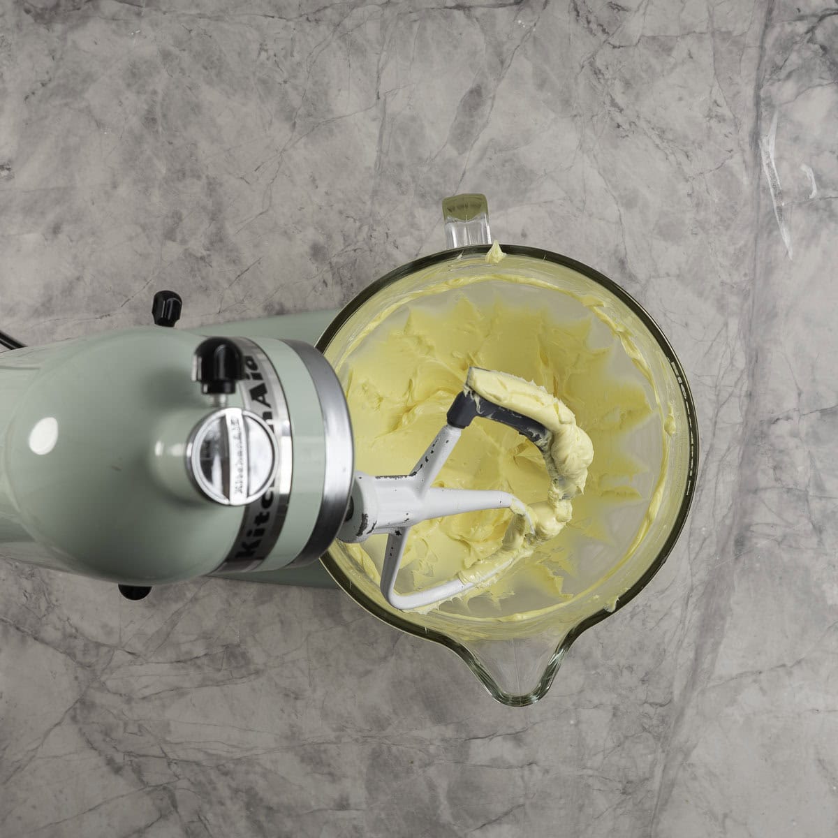 Butter that has been beaten to pale colour in a stand mixer with a glass bowl.